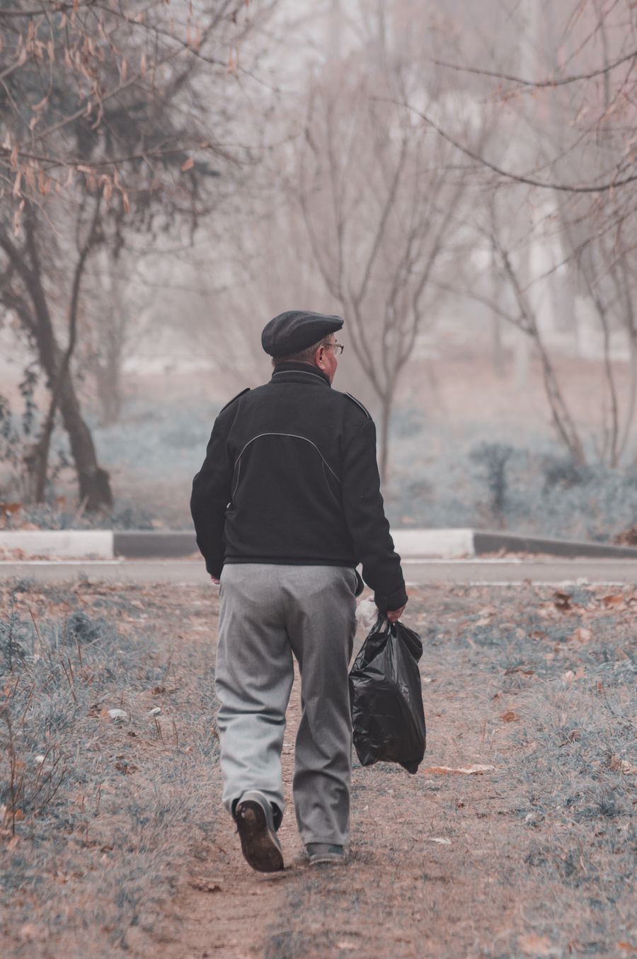 Uomo che passeggia lungo un viale alberato