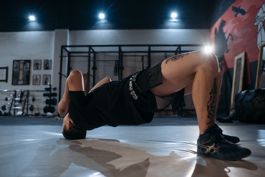 Uomo che esegue il ponte per i glutei sul pavimento